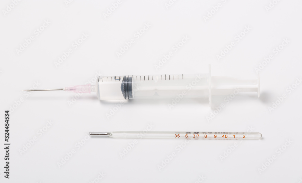 Syringe and miniature human and oral medicine and thermometer macro closeup on white background Syringe and miniature human and oral medicine and thermometer macro closeup on white background