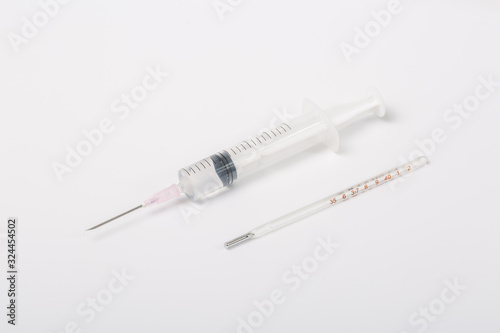  Syringe and miniature human and oral medicine and thermometer macro closeup on white background