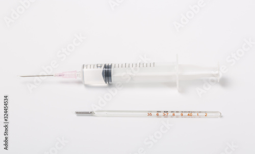  Syringe and miniature human and oral medicine and thermometer macro closeup on white background