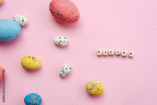 Happy Easter concept. Colorful eggs are laid out on a cute  pink background.