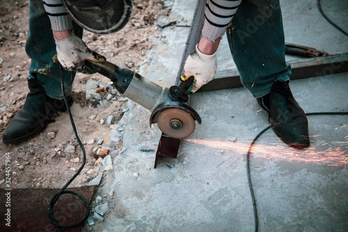 A worker cuts metal at a construction site