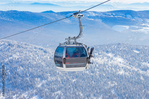 Cabin lift for ski resort on background of mountains and blue sky, sunny day