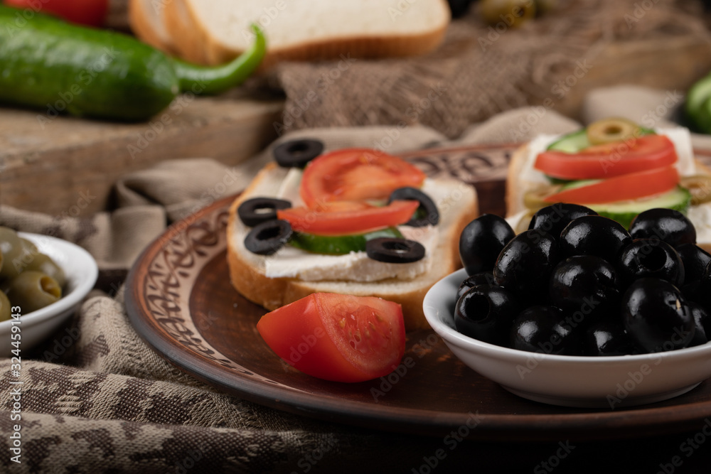 Sandwiches with tomato and black olives.