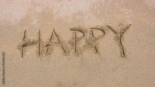 Happy text on sand beach background