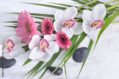 beautiful bouquet of white orchids and pink daisies in leaf and pebbles on wh...