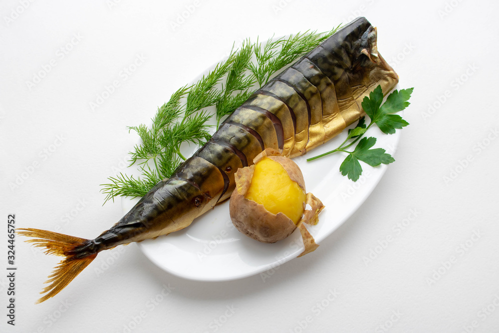 Plate with baked mackerel stuffed with herbs, onions and boiled potatoes with spices and butter on a textured gray background, selective focus. Healthy diet. Plate with baked mackerel stuffed with herbs, onions and boiled potatoes with spices and butter on a textured gray background, selective focus. Healthy diet.