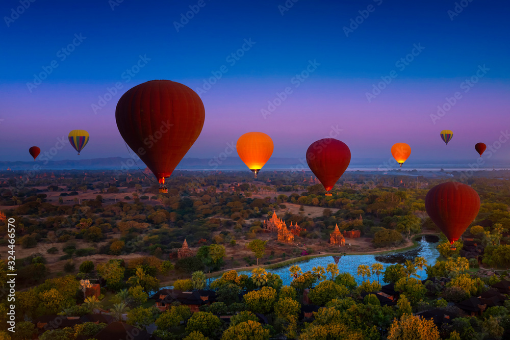 Fototapeta premium Sunset many hot air balloon with stupas in Bagan, Myanmar. Bagan is an ancient with many pagoda of historic buddhist temples and stupas. space for text.