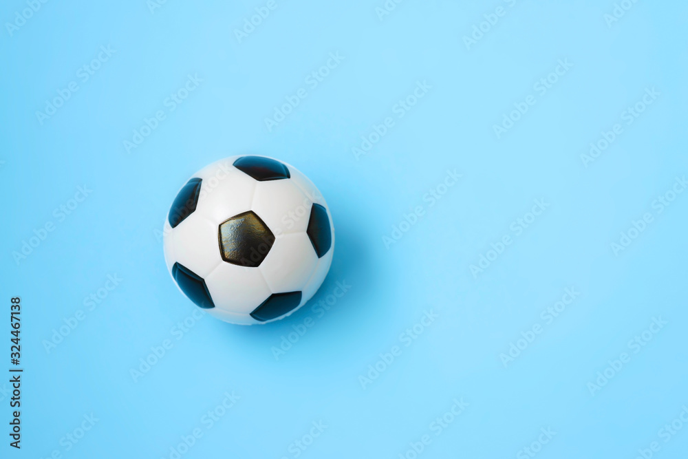 Fototapeta premium Miniature soccer ball on a blue background. World championship. Physical development of the child. How much does health cost? Sports and money.