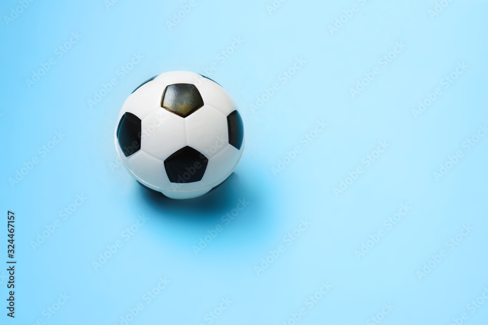 Miniature soccer ball on a blue background. World championship. Physical development of the child. How much does health cost? Sports and money.