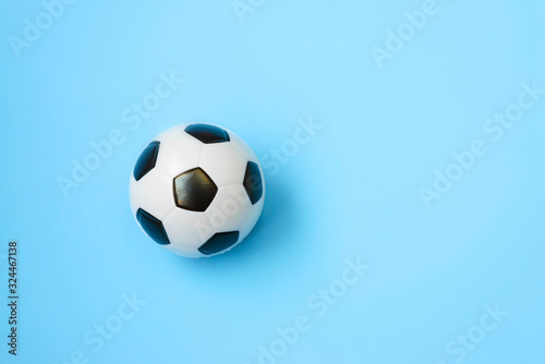 Fototapeta Naklejka Na Ścianę i Meble -  Miniature soccer ball on a blue background. World championship. Physical development of the child. How much does health cost? Sports and money.