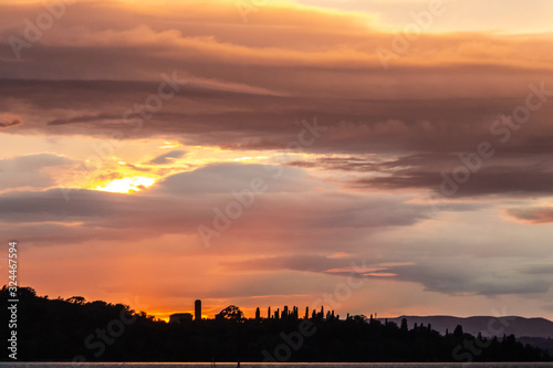 View of Isola Maggiore on Trasimeno lake at dusk  beneath a dramatic  beautidul sky