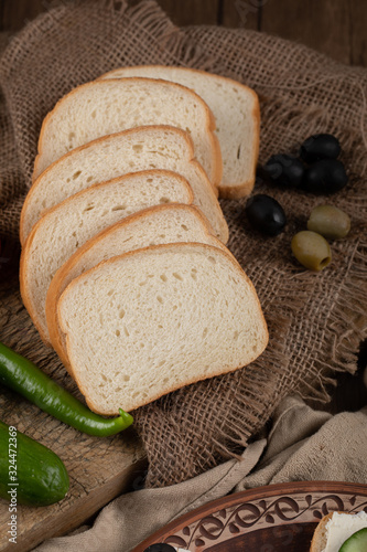 Finely sliced white bread in rustic background.