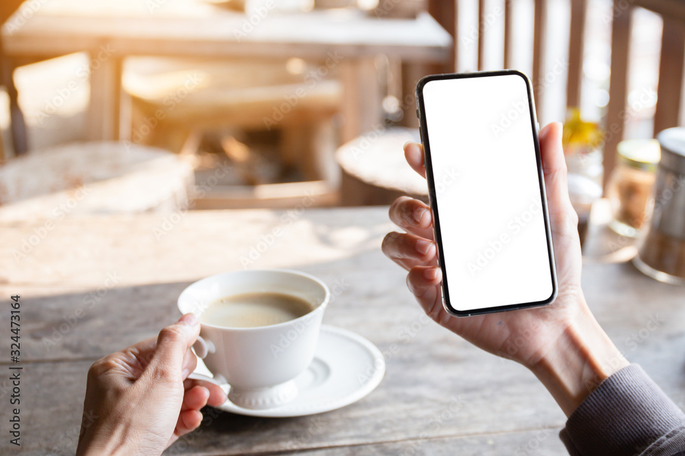 Mockup image blank white screen cell phone.man hand holding texting using mobile on desk at coffee shop.background empty space for advertise text.people contact marketing business,technology Mockup image blank white screen cell phone.man hand holding texting using mobile on desk at coffee shop.background empty space for advertise text.people contact marketing business,technology