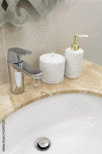 Fototapeta Naklejka Na Ścianę i Meble -  Marble sink, chrome faucet and bathroom accessories. Modern bathroom design.