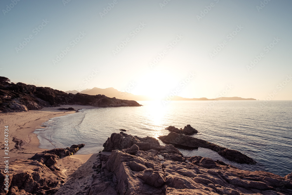 Sun setting over beach and calvi citadel in Corsica