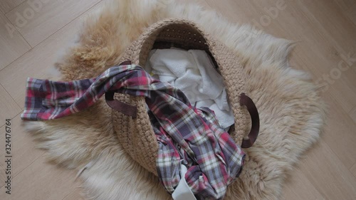 Slow Motion of sleepwear pajamas filling into a laundry basket on a floor