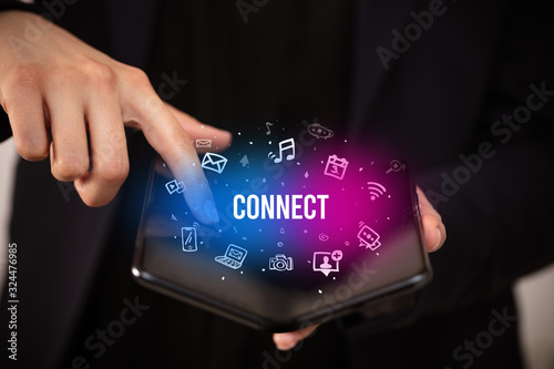 Businessman holding a foldable smartphone with CONNECT inscription, social media concept