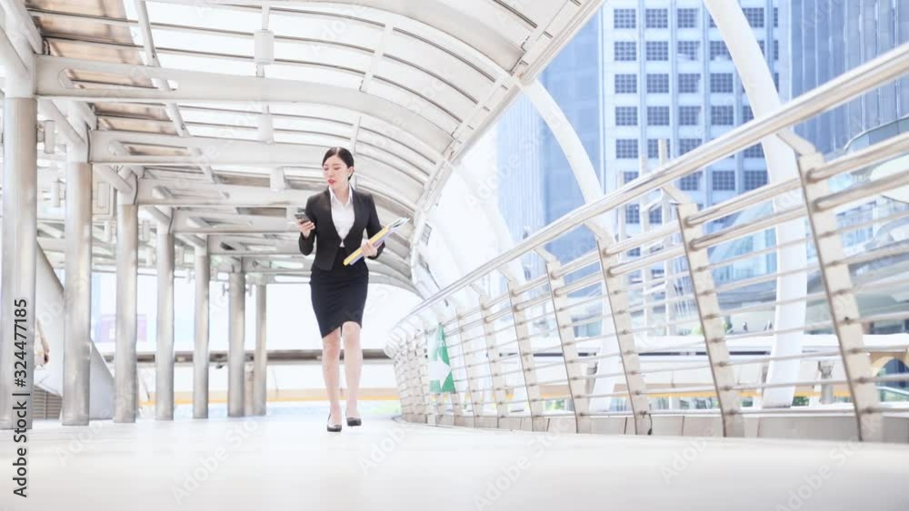 Young Asian business woman receive calling and runs down in the city street. Businessman late for meeting. Young Asian business woman receive calling and runs down in the city street. Businessman late for meeting.