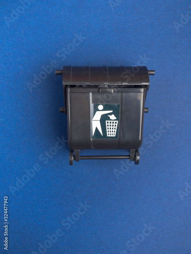 Black trash toy can or recycle bin on blue background