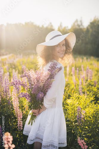 Beautiful woman with a bouquet of flowers in the field