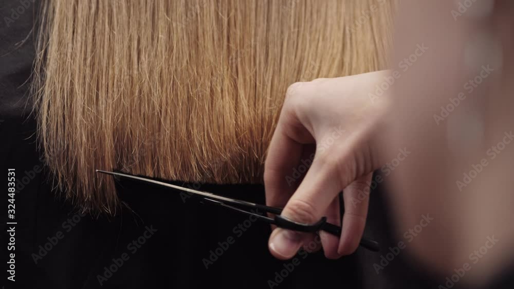 Hair salon girl haircuts. Close up 4K slow motion. Align the hair length