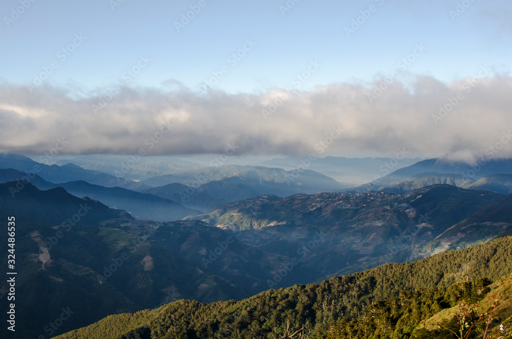 shining through clouds to mountains in different layers