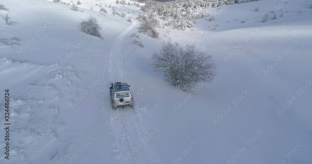 Driving car at snow covered closed mountain road. Aerial view. Driving car at snow covered closed mountain road. Aerial view.