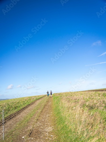 long distant runners cresting a hill © NosamA