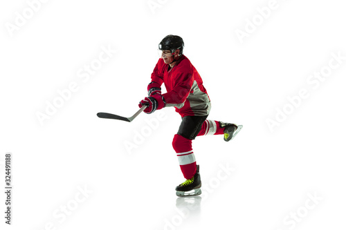 Leader. Male hockey player with the stick on ice court and white background. Sportsman wearing equipment and helmet practicing. Concept of sport, healthy lifestyle, motion, movement, action.