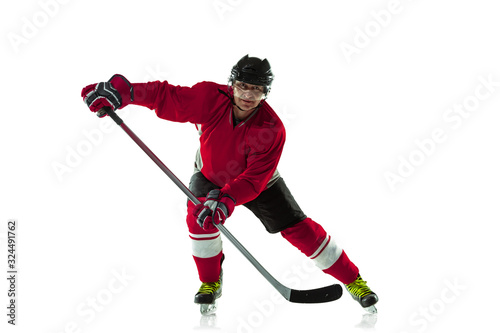 Scoring a goal. Male hockey player with the stick on ice court and white background. Sportsman wearing equipment and helmet practicing. Concept of sport, healthy lifestyle, motion, movement, action. © master1305