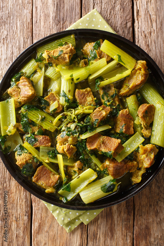 Celery stew Khoresh Karafs is healthy and delicious Iranian dish. It's a combination of meat, evenly sliced celery  and herbs closeup in the plate. Vertical top view photo