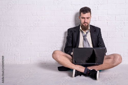 Business man in a jacket and shorts working on the laptop remotely. Workaholic working on weekends.