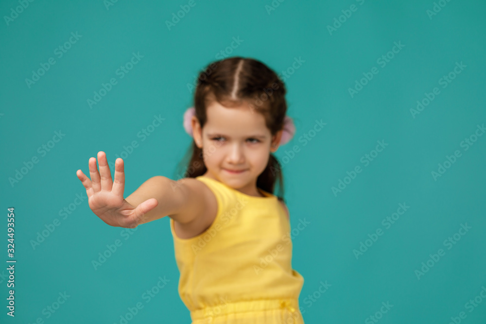 Cute little child girl making stop gesture on blue background. focus on hand Cute little child girl making stop gesture on blue background. focus on hand