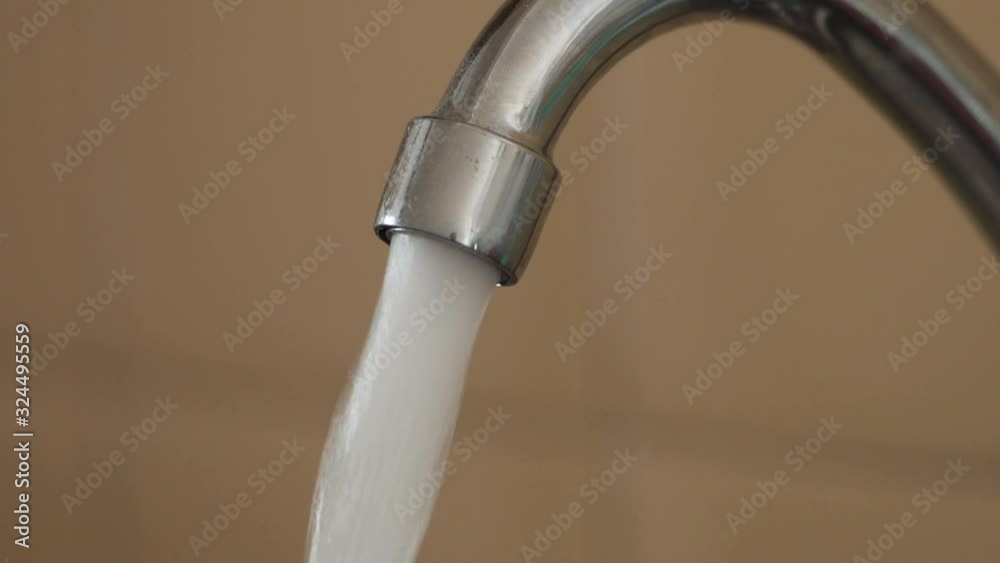 Kitchen faucet streaming clean water at full pressureb close-up Kitchen faucet streaming clean water at full pressureb close-up