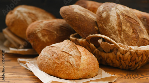 Assortment of baked bread on wooden table background. Bread background, top view of white, black and rye loaves. Healthy food. 