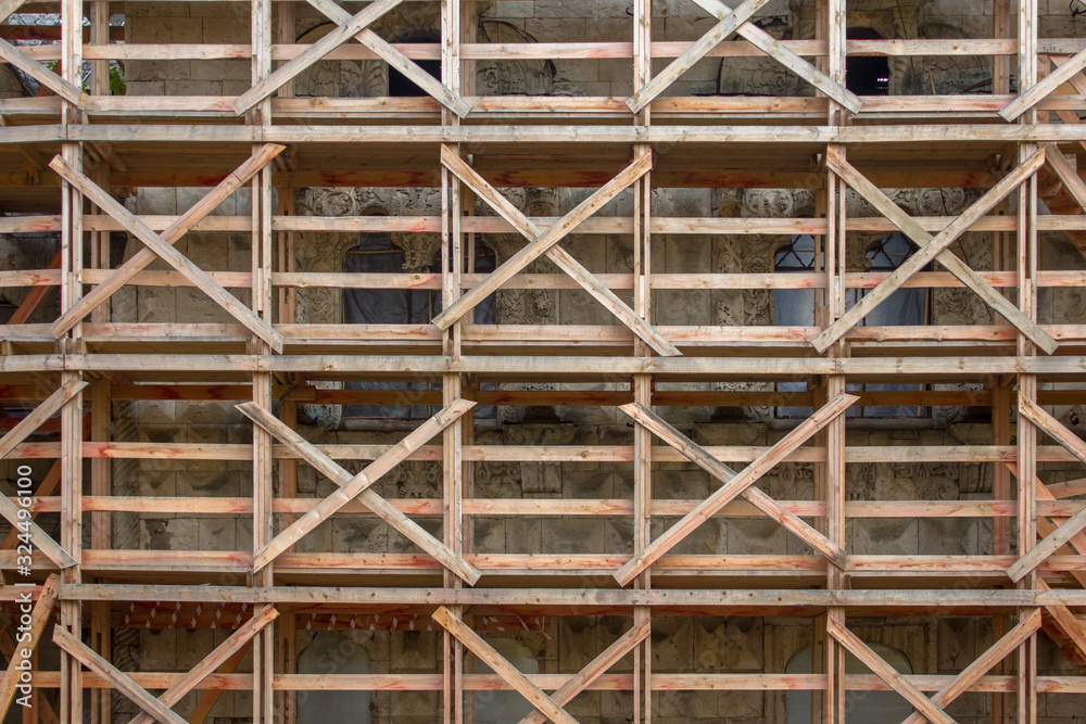 wooden scaffolding during the restoration of an ancient stone cathedral wooden scaffolding during the restoration of an ancient stone cathedral