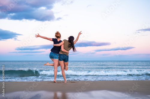 Two pretty young girls pretty best friend women having fun on their summer vacation on Mediterranean sea, mini denim shorts, amazing blonde and brunette hairs, traveling experience, happy emotions