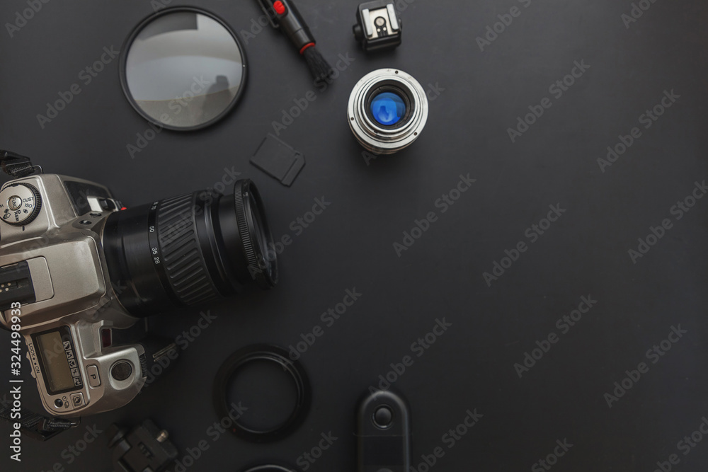Photographer workplace with dslr camera system, camera cleaning kit, lens and camera accessory on dark black table background. Hobby travel photography concept. Flat lay top view copy space.