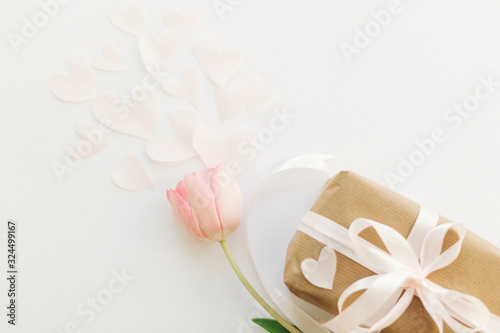 Romantic Valentines day. Pink tulip flat lay and gift box with ribbon on white background, space for text. Stylish soft spring image. Happy womens day. Greeting card mockup. Happy Mothers day