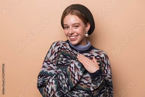 Photo of pretty joyful woman smiling and holding hands on her chest