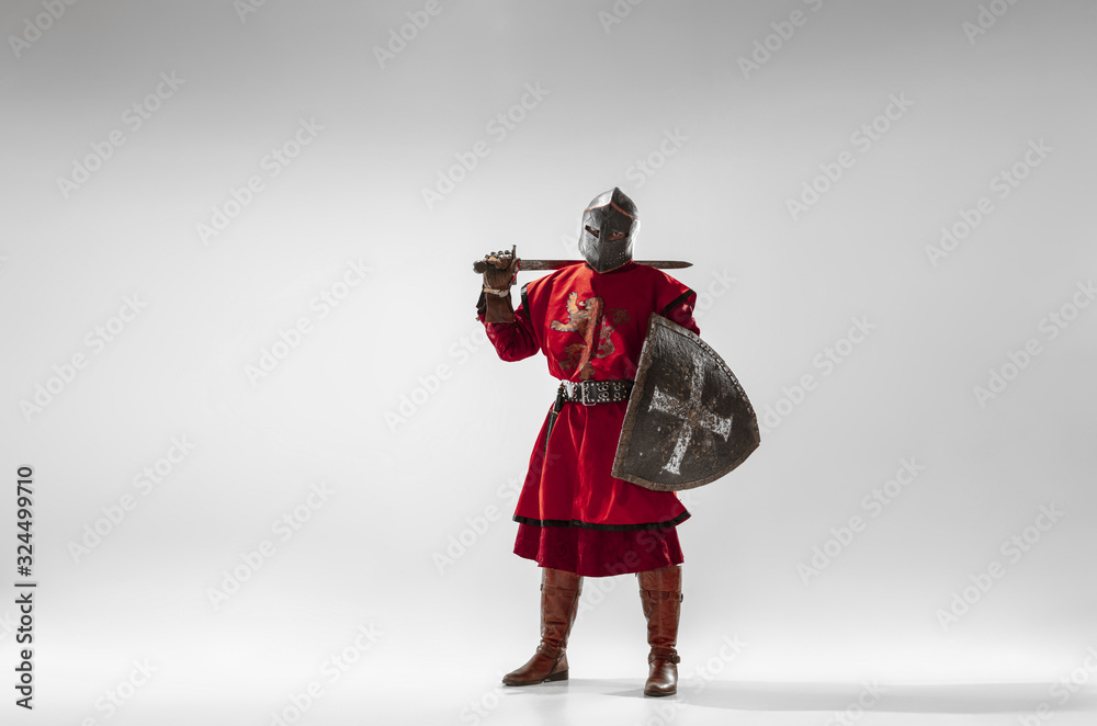 Brave armored knight with professional weapon fighting isolated on white studio background. Historical reconstruction of native fight of warriors. Concept of history, hobby, antique military art.