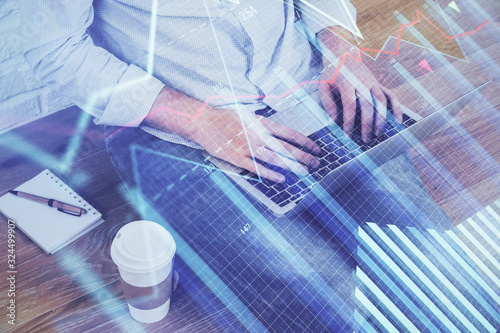 Forex graph with businessman working on computer in office on background. Concept of analysis. Double exposure.