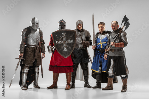 Brave armored knights with professional weapon fighting isolated on white studio background. Historical reconstruction of native fight of warriors. Concept of history, hobby, antique military art.