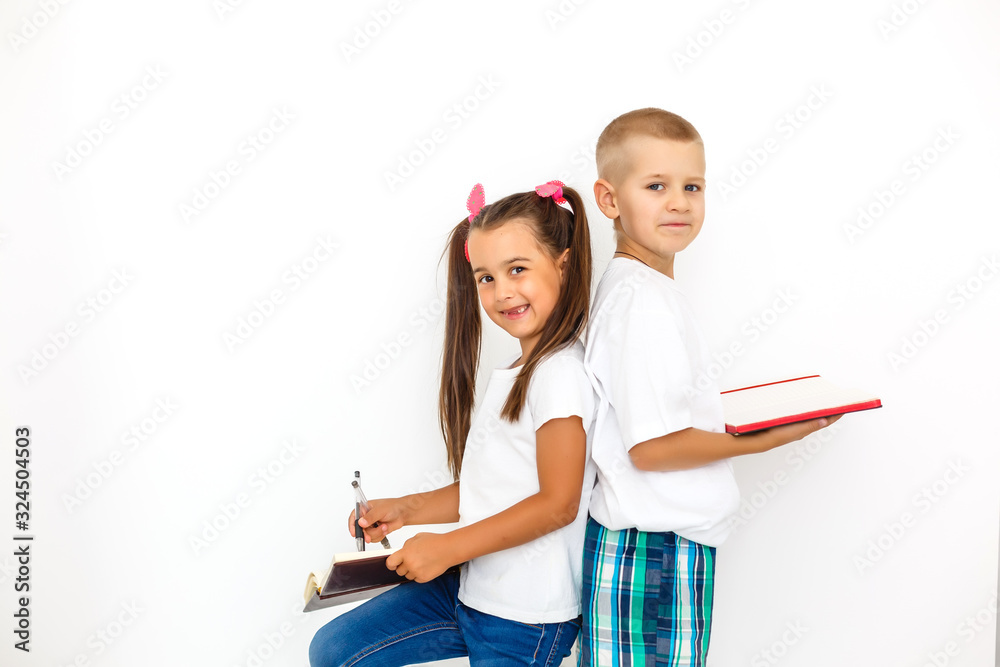 Children's fashion. Modern boy and girl posing together at studio. Education. Children's fashion. Modern boy and girl posing together at studio. Education.