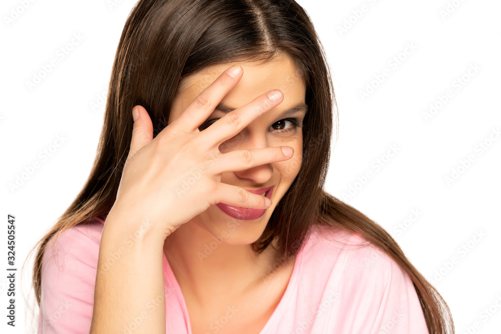 Shy young smiling woman covering her face with her hand Shy young smiling woman covering her face with her hand