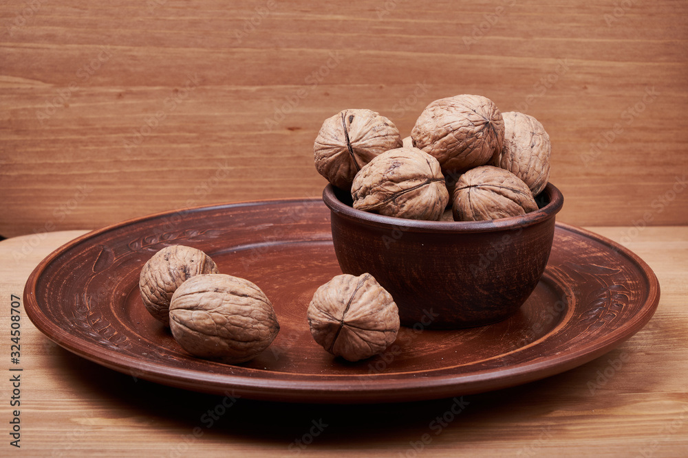 Walnut kernels and whole walnuts on rustic old wooden table Walnut kernels and whole walnuts on rustic old wooden table
