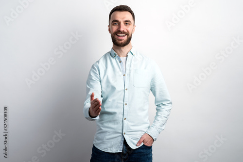 Portrait of happy man .holds out his hand for greeting looking at the camera © speed300