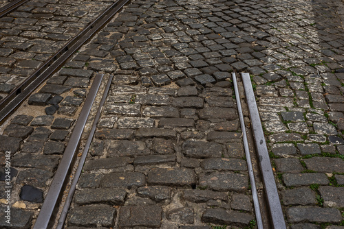 cuted tram iron rails on cobblestone street
