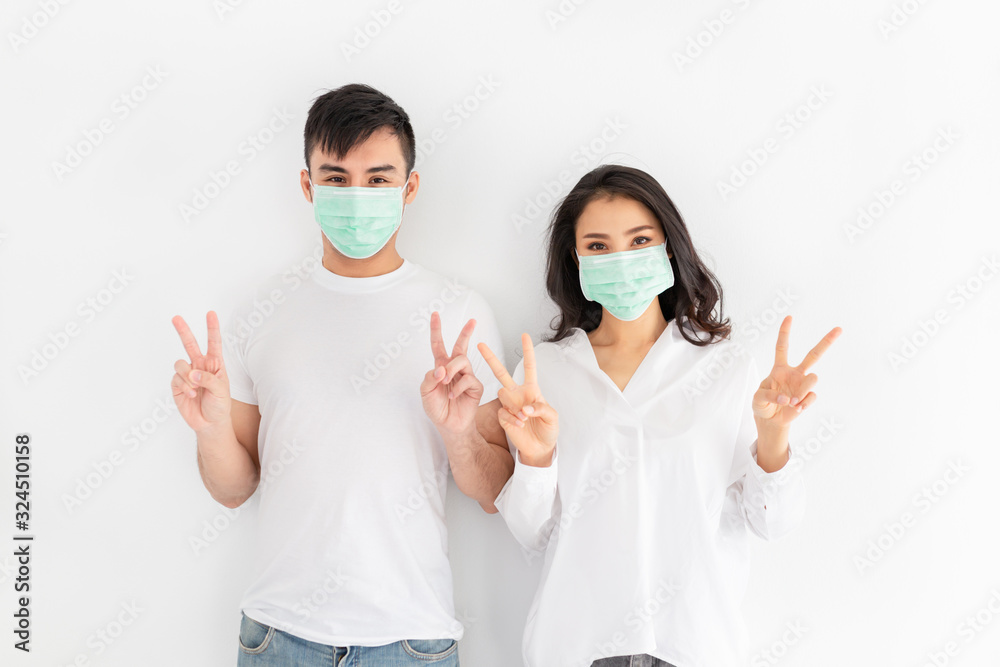 couple asian people wear surgical mask on white background, they want to pollution protection and virus protection, they show v sign with hands, healthcare and infection control couple asian people wear surgical mask on white background, they want to pollution protection and virus protection, they show v sign with hands, healthcare and infection control