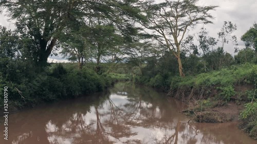 Forwards aerial drone view of river in African landscape in Laikipia, Kenya photo